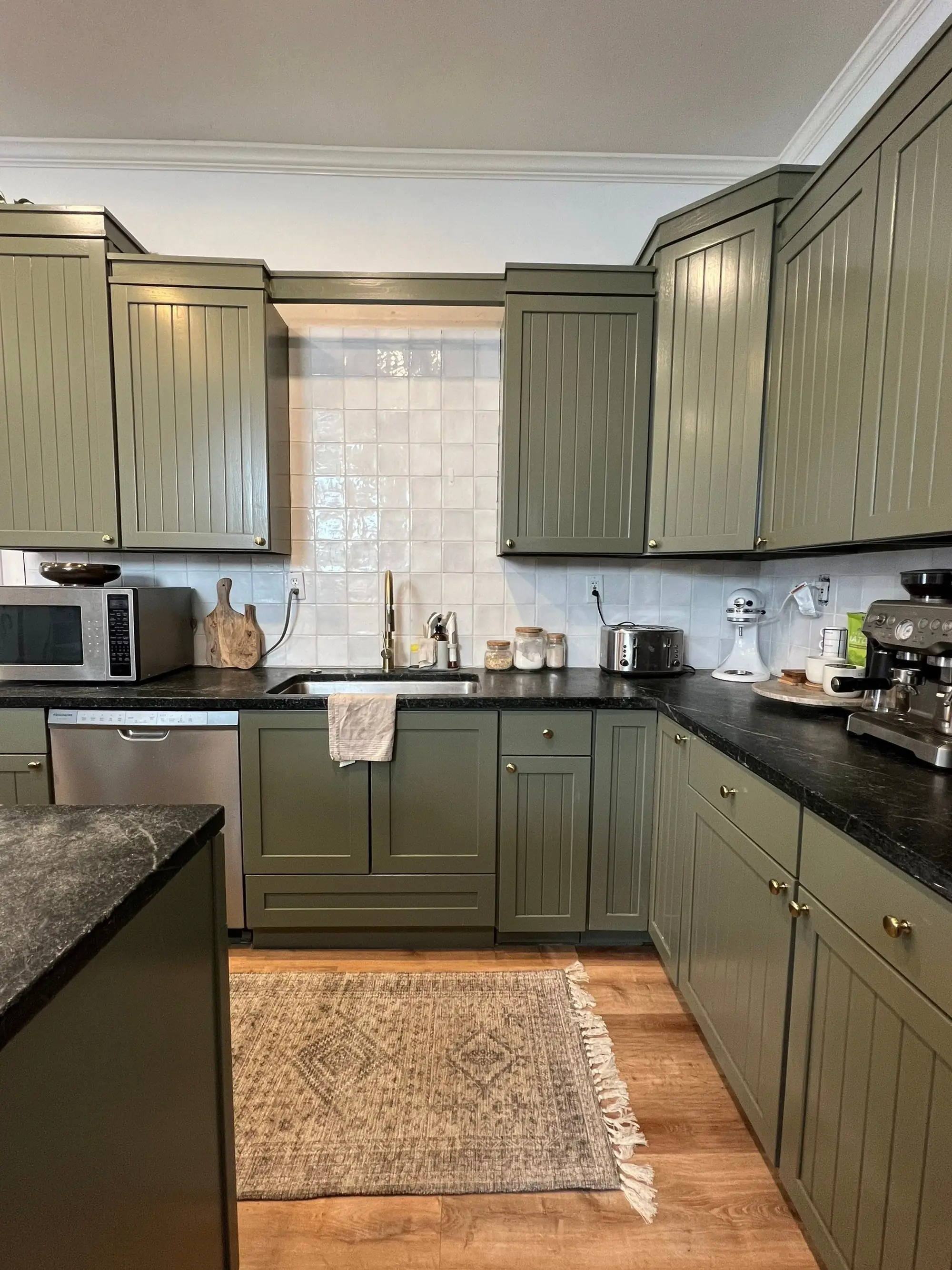 A Denver kitchen with freshly repainted olive green cabinets by Kind Home Painting